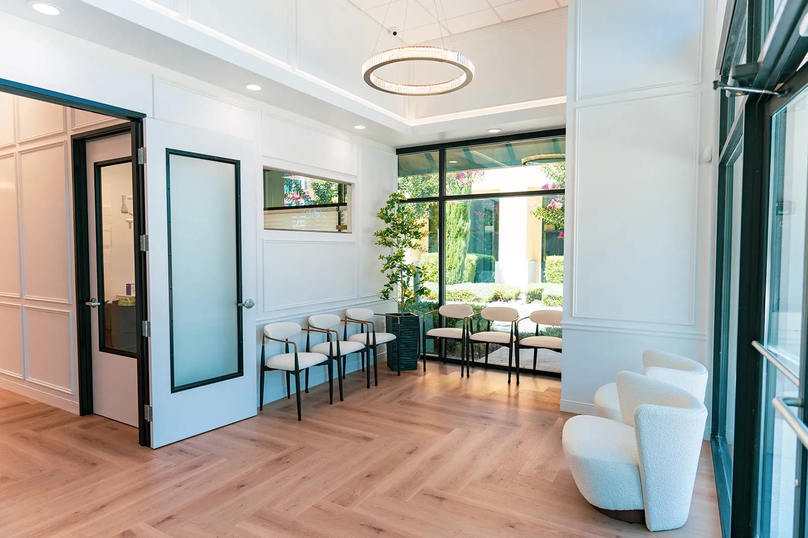 Bright, modern waiting area with herringbone wood floors and natural light