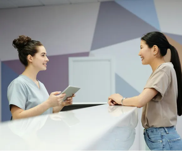 Reception team greeting a patient at the front desk